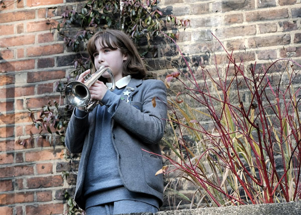 A child playing a trumpetDescription automatically generated with medium confidence
