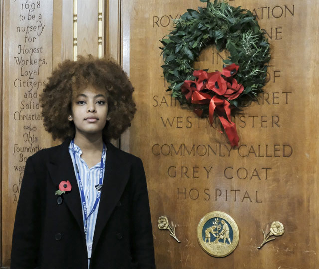 A person standing next to a tombstoneDescription automatically generated with low confidence