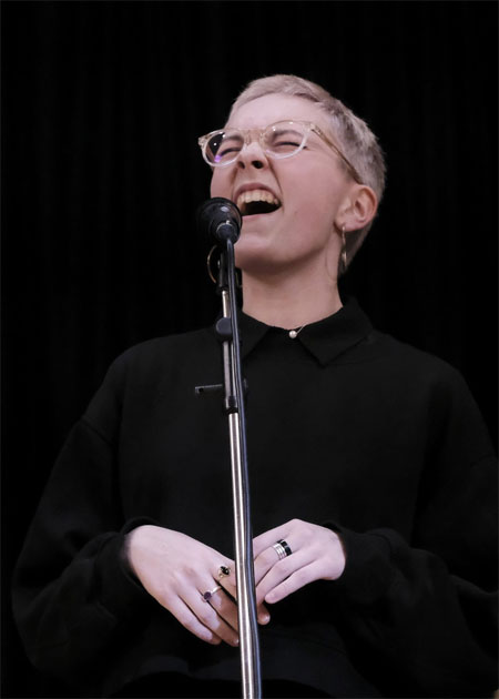 A person singing into a microphoneDescription automatically generated