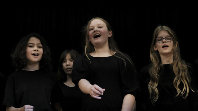 A group of women singingDescription automatically generated with low confidence